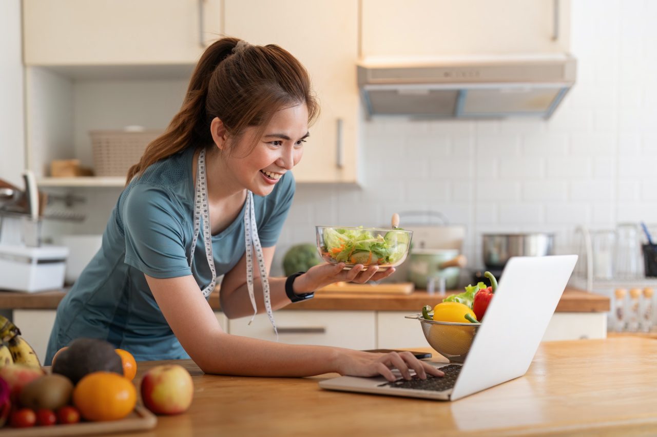 young woman eat healthy food sitting in the kitchen